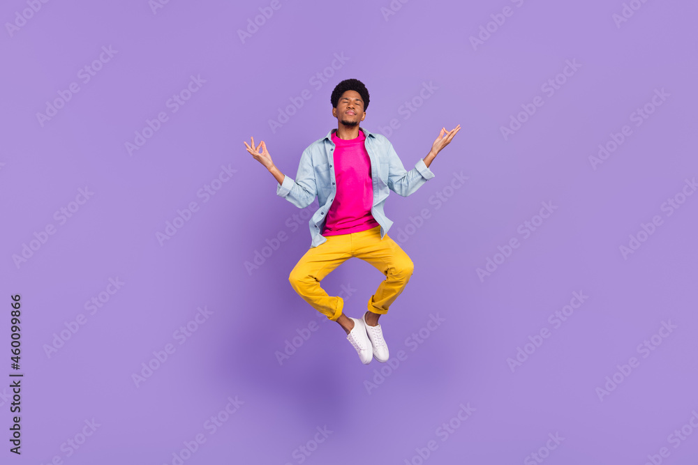 Photo of peaceful guy jump yoga practice close eyes wear blue shirt pants shoes isolated purple color background