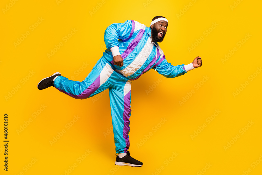 Photo of impressed sweet dark skin man wear blue suit headband dancing smiling isolated yellow color background Photo of impressed sweet dark skin man wear blue suit headband dancing smiling isolated yellow color background