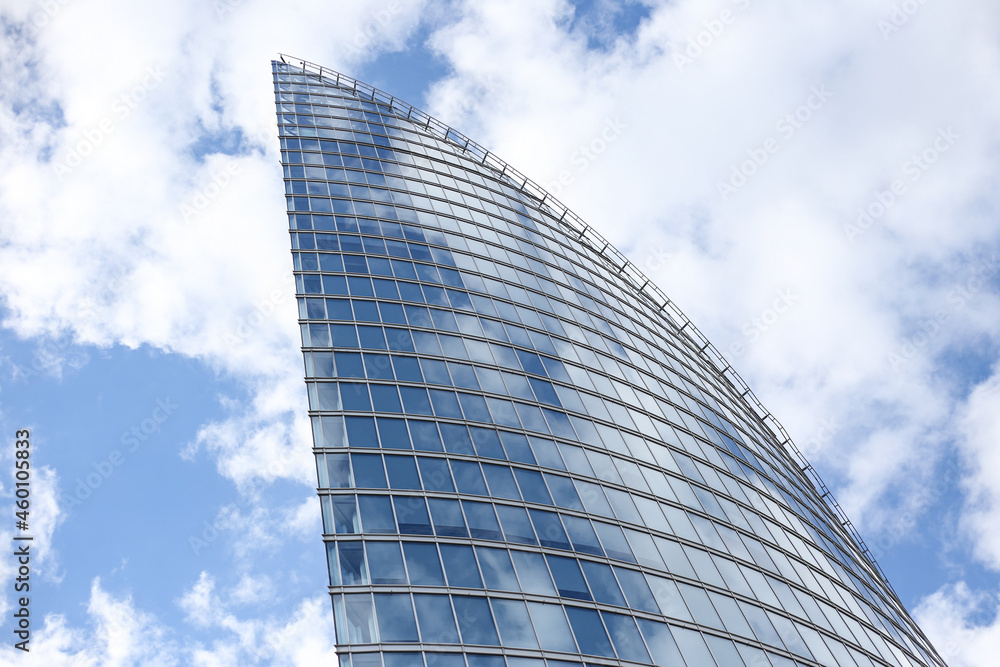 Close up abstract modern skyscraper architecture tall glass building with clouds in background. Close up abstract modern skyscraper architecture tall glass building with clouds in background.