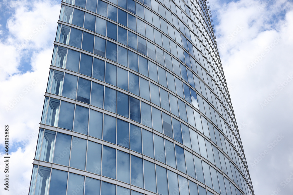 Close up abstract modern skyscraper architecture tall glass building with clouds in background. Close up abstract modern skyscraper architecture tall glass building with clouds in background.