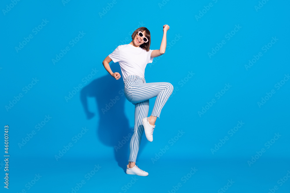 Full length body size photo careless girl in sunglass gesturing like winner isolated bright blue color background