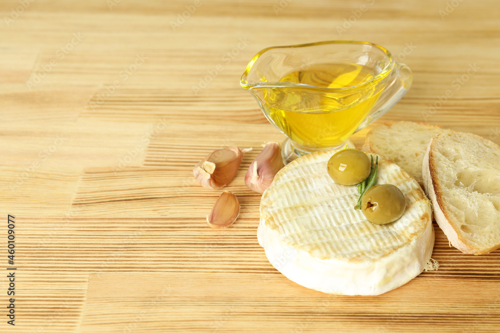 Concept of tasty food with grilled camembert on wooden background Concept of tasty food with grilled camembert on wooden background