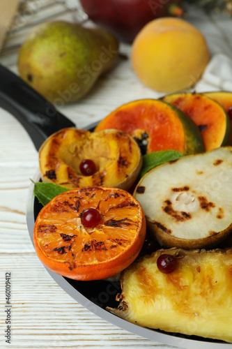 Concept of tasty food with grilled fruits on white wooden table