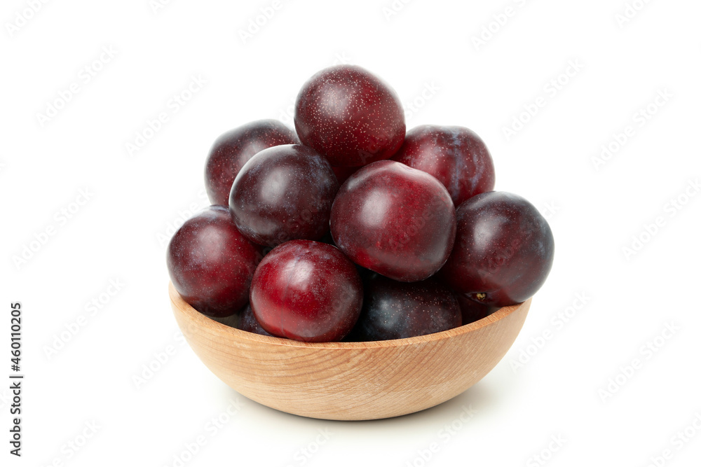 Wooden bowl with plums, isolated on white background