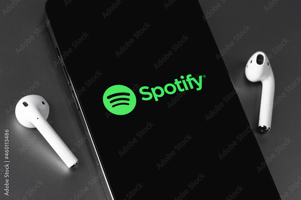 Spotify mobile logo app on screen smartphone iPhone with AirPods headphones  on grey background. Spotify - online streaming audio service. Moscow,  Russia - June 10, 2021 Photos | Adobe Stock