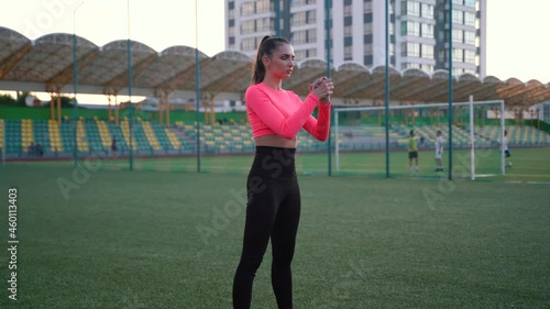 Fitness woman in sportswear doing various exercises on sports mat, on green football field with white markings, at stadium. Outdoor sports. online training. hot summer day. healthy lifestyle concept