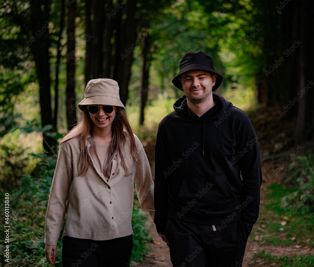 Man and woman walking and laughing holding hands in the forest Man and woman walking and laughing holding hands in the forest
