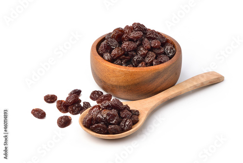 Raisins in wooden bowl and spoon  isolated on white background.