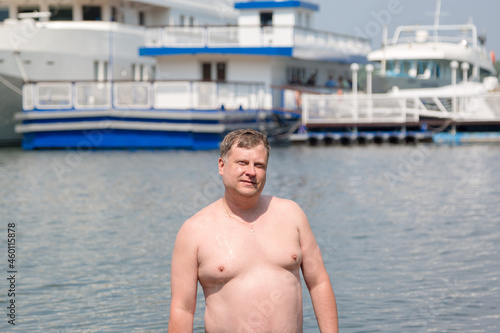 young oligarch swims in the sea against the background of his own yacht. photo