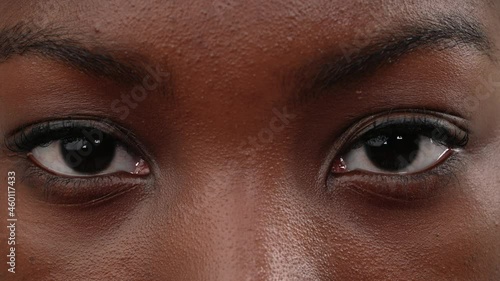 Close up of a black woman face opening her eyes. Macro.