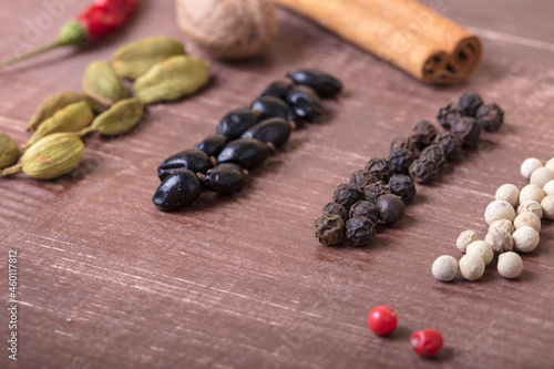 Cardamom, nutmeg, cinnamon and other aromatic spices lie on a wooden table