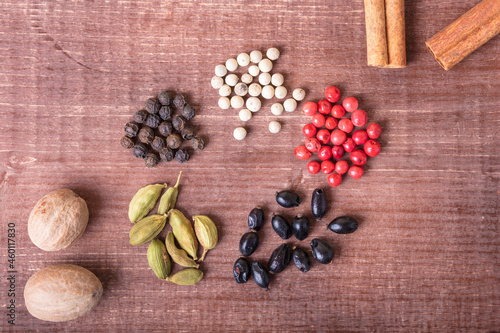 Fototapeta Naklejka Na Ścianę i Meble -  Cardamom, nutmeg, cinnamon and other aromatic spices lie on a wooden table