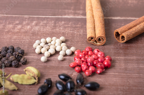 Cardamom, nutmeg, cinnamon and other aromatic spices lie on a wooden table