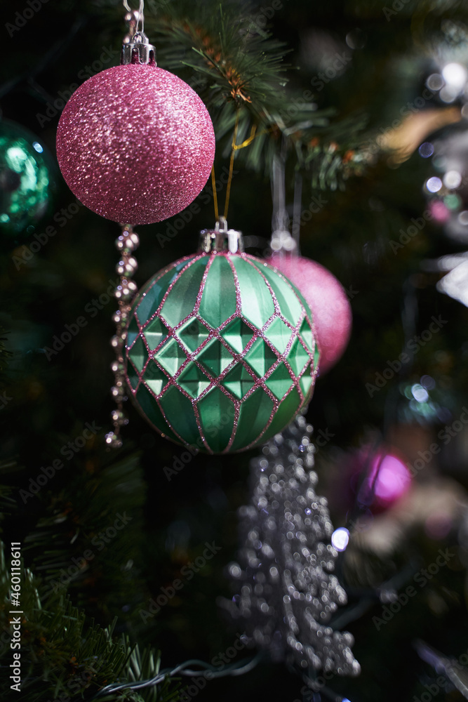 Obraz premium Christmas decoration in the form of a green and pink ball on a Christmas tree along with other decorations