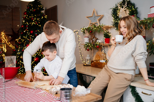 happy family prepares traditional dishes from dough for new year.mom is pregnant photo