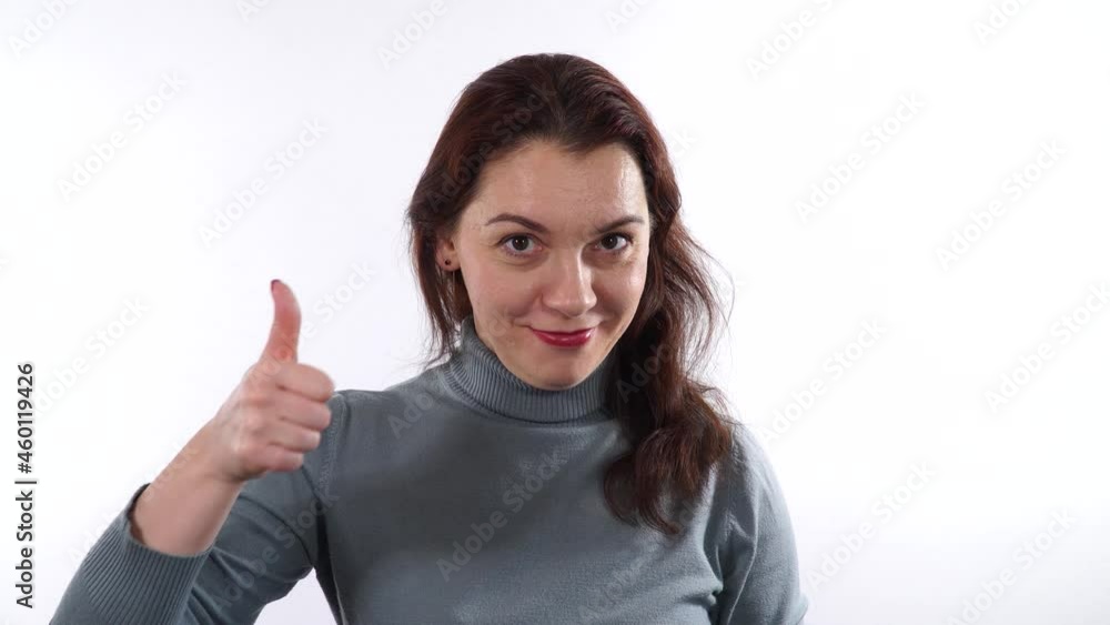 Beautiful woman 30-35 years old brunette shows OK signal, thumb up. Thumb up gesture. White background. Beautiful woman 30-35 years old brunette shows OK signal, thumb up. Thumb up gesture. White background.