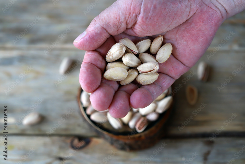 Selective focus. Macro. Pistachios in hand. Selective focus. Macro. Pistachios in hand.