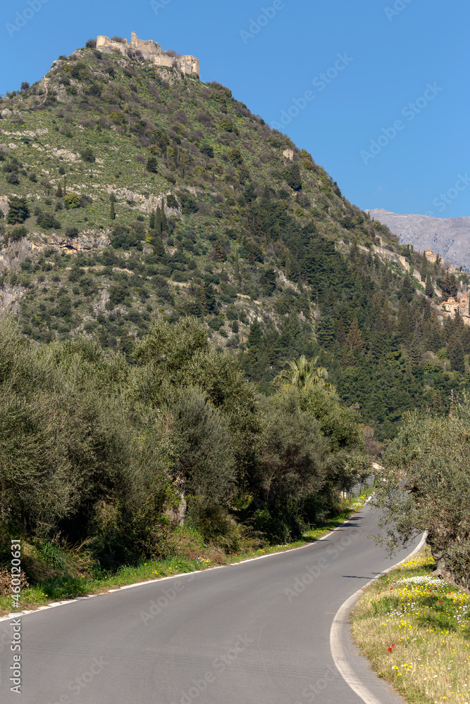 The road in a village Mystras (Greece, Peloponnese) and view of the fortress on the mountain