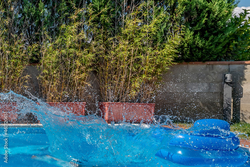 Fototapeta Naklejka Na Ścianę i Meble -  A huge splash of water is created by a cannonball dive into a swimming pool