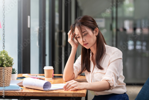 Overworked young Asian businesswoman causing stress bored at the office. © amnaj