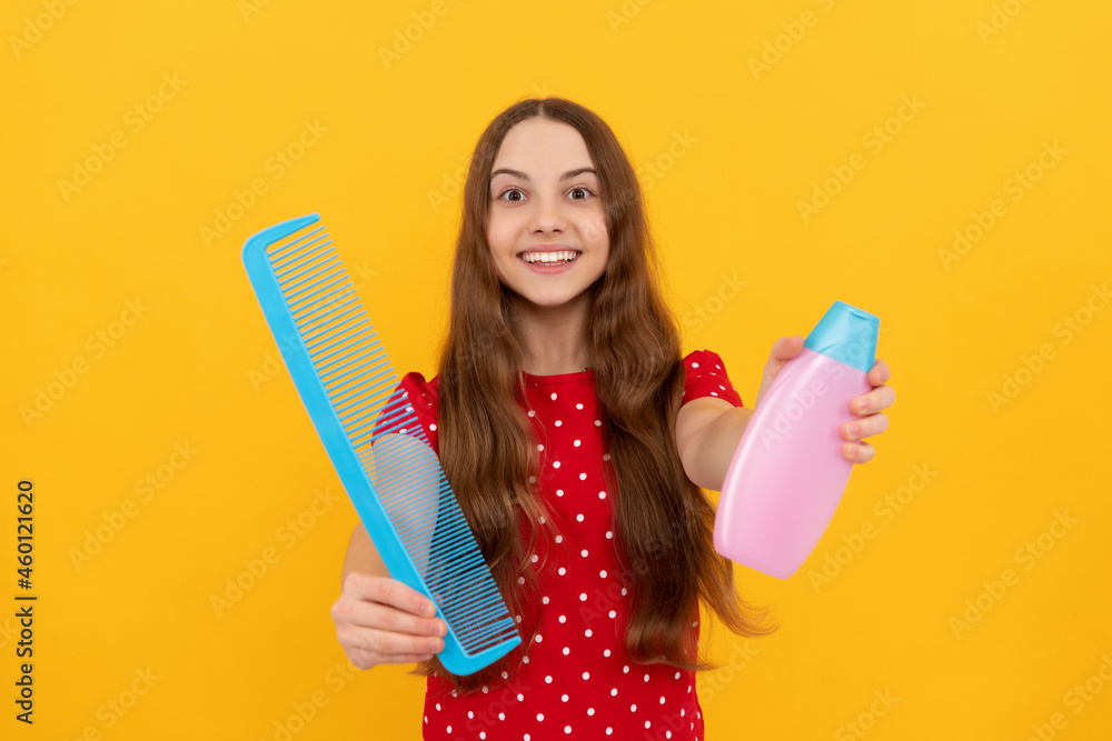 amazed girl wavy hairdo hold hairbrush. teen beauty hairstyle. frizz child with conditioner amazed girl wavy hairdo hold hairbrush. teen beauty hairstyle. frizz child with conditioner