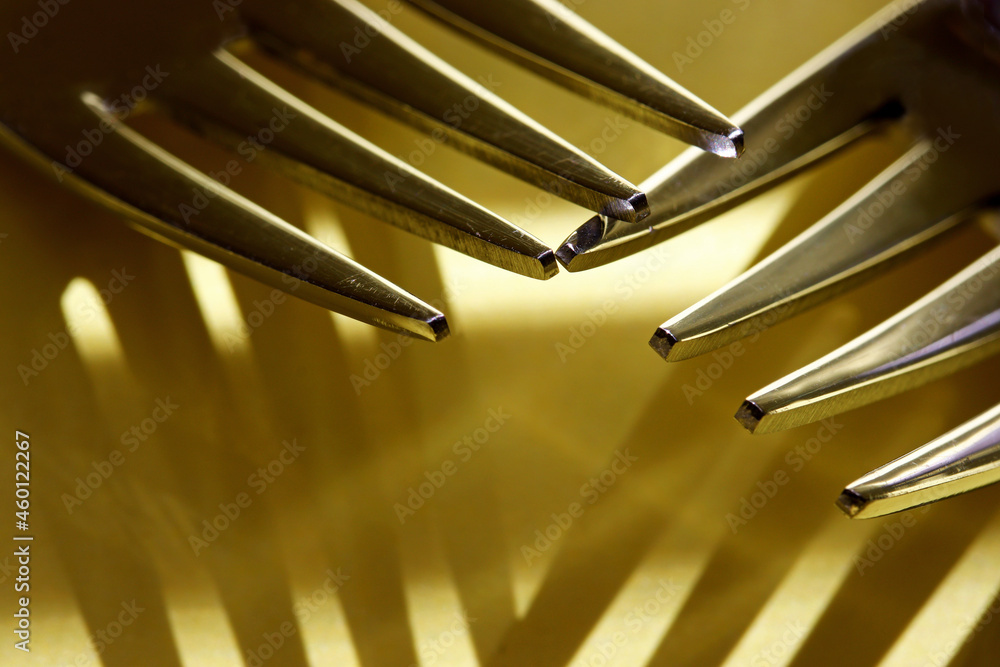 close-up metal fork with shadows on yellow background close-up metal fork with shadows on yellow background