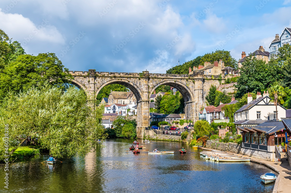 A view along the River Nidd towards the viaduct in the town of Knaresborough in Yorkshire, UK in summertime