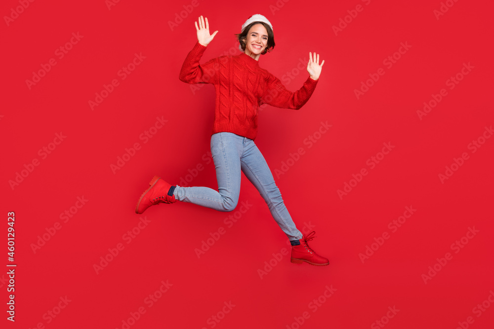 Full length body size photo woman in headwear jumping waving hand on meeting isolated vivid red color background