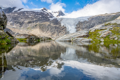 Mountain Glacier in alpine valley reflected in water. Schlaten Glacier, German: Schlatenkees, Hohe Tauern National Park, East Tyrol, Austrian Alps