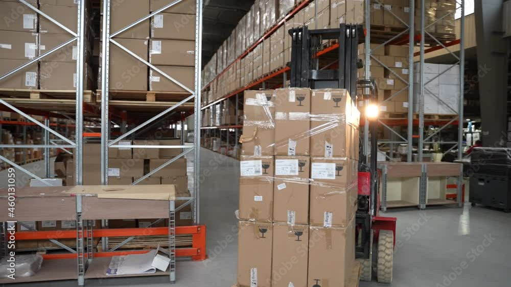 Professional forklift driver moving huge pallet of cardboard boxes ...