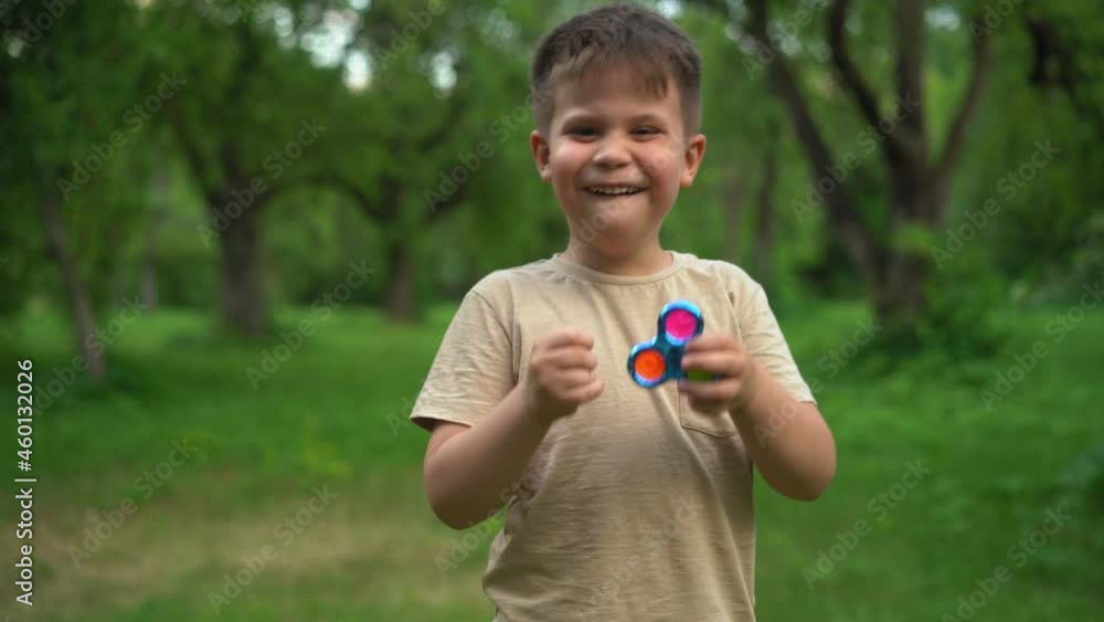 Child is Having Fun and Playing an Anti-Atress Toy. Kid is Playing Trendy Popular Game Toy Pop It in Garden. High quality 4k footage Child is Having Fun and Playing an Anti-Atress Toy. Kid is Playing Trendy Popular Game Toy Pop It in Garden. High quality 4k footage