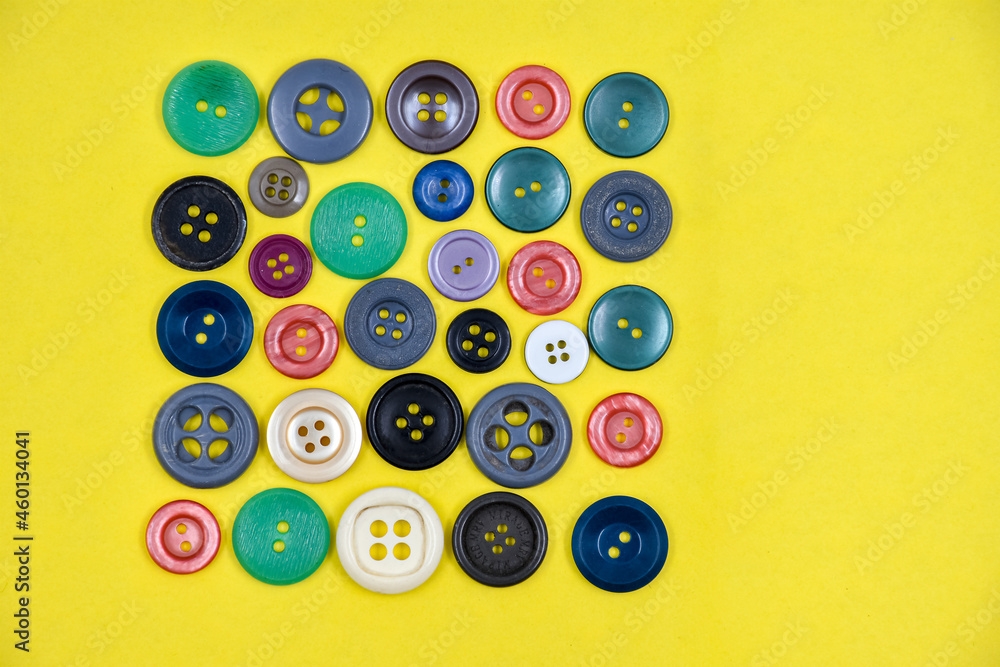 A variety of buttons on a yellow background A variety of buttons on a yellow background