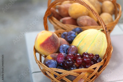 Two baskets full of fresh fruit and vegetable in a garden. Selective focus.