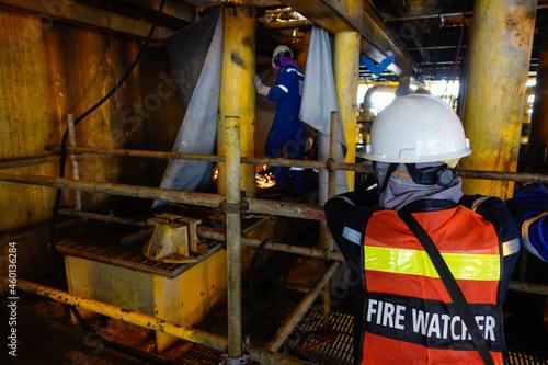 Fire watcher watch welder weld gas pipe casing for stop work in case of gas explosive, working in offshore oil and gas platform.