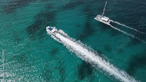 Bote y catamaran en playa cristalina azul tomada desde un Drone photo