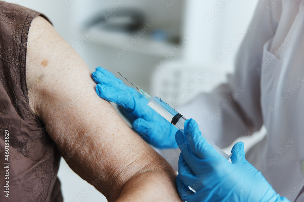 doctor makes an injection in the arm covid-19 passport close-up doctor makes an injection in the arm covid-19 passport close-up
