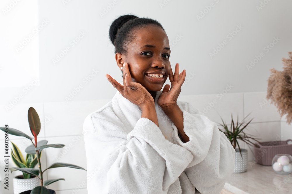 Beautiful dark skinned girl admiring herself touching cheeks Beautiful dark skinned girl admiring herself touching cheeks
