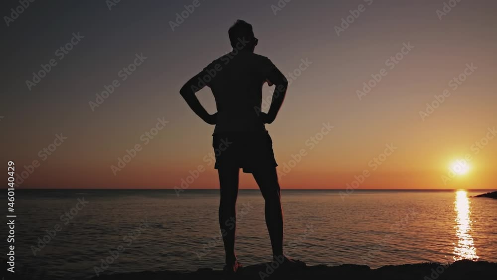 Silhouette of a man watching sunset over distant horizon. Silhouette of a man watching sunset over distant horizon.