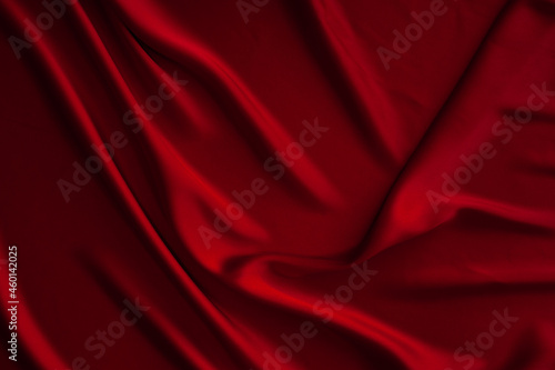 Red fabric texture background. Silk satin folds