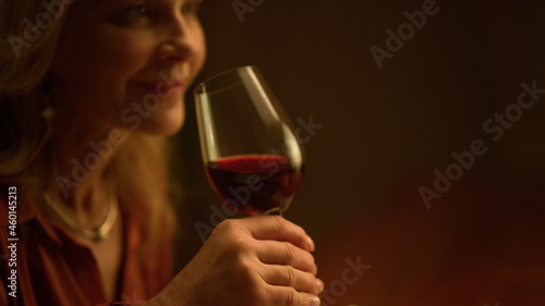 Old aged woman drinking red wine glass indoor. Rich retirement lifestyle concept