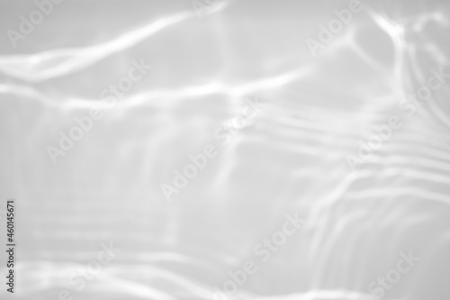 Blurred defocused water texture overlay effect for photo and mockups. Organic drop diagonal shadow and light caustic effect on a white wall. Shadows for natural light effects