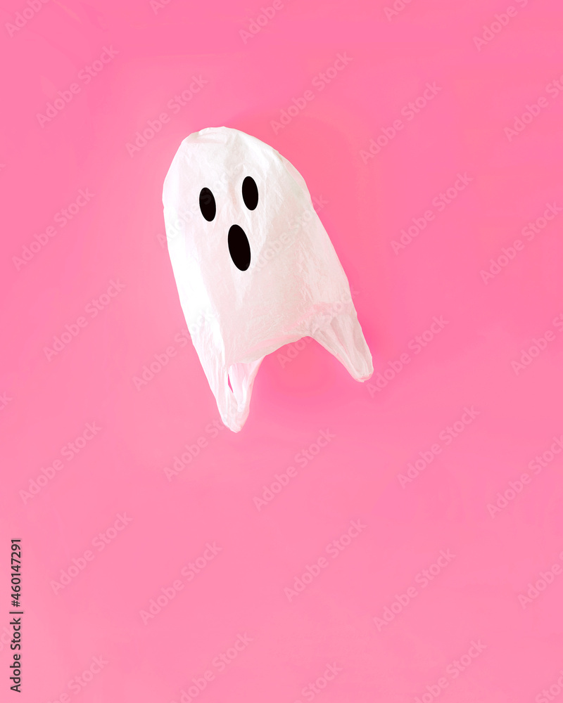 A shopping bag in the shape of a scary ghost for Halloween. The concept of minimal composition on a pink background. A shopping bag in the shape of a scary ghost for Halloween. The concept of minimal composition on a pink background.