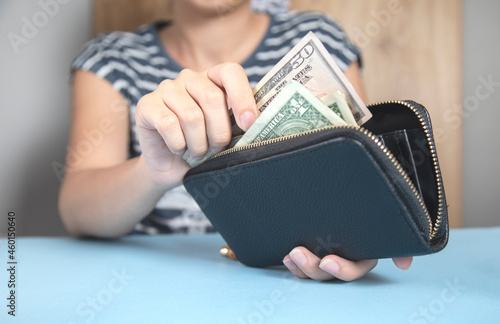 woman holding wallet and money