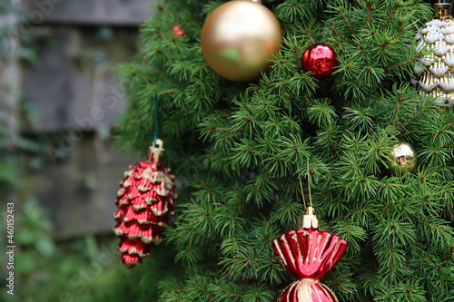 Christmas decorations of different types and colors on a fir tree. Blue and red candy, golden balls on Christmas tree. 