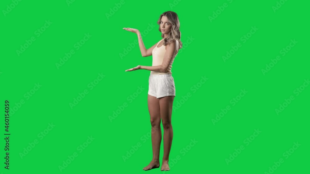 Cute woman in pajamas presenting and promoting empty copy space. Full body on green screen chroma key background Cute woman in pajamas presenting and promoting empty copy space. Full body on green screen chroma key background