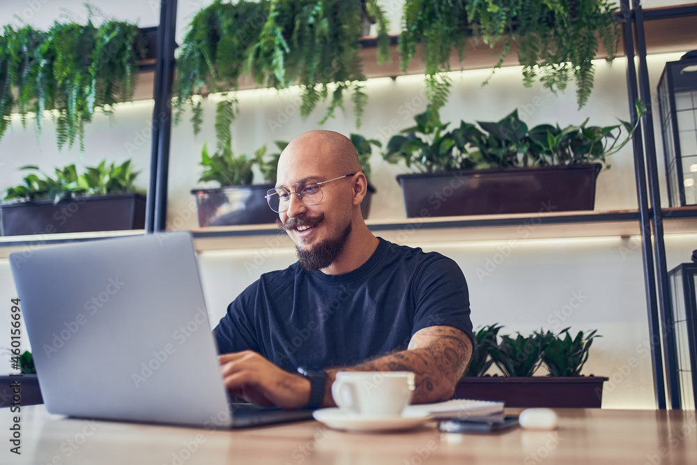 Millennial caucasian man works on computer at home office holds a pen in his hand. Distance Job Millennial caucasian man works on computer at home office holds a pen in his hand. Distance Job