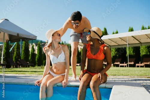 Three friends rest at the edge of the pool © Nomad_Soul