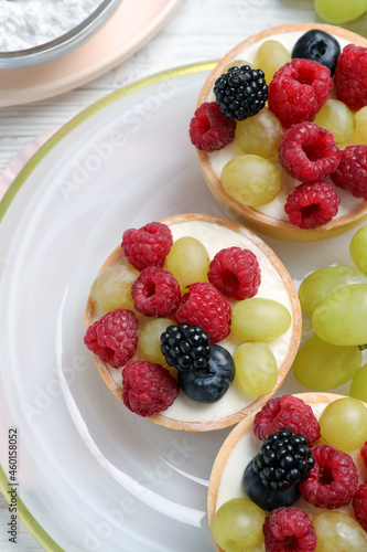 Delicious tartlets with berries on white table  top view