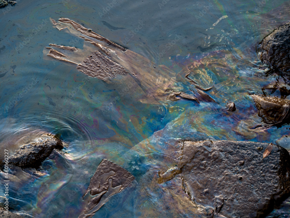 Dirty oily film on the surface of the turquoise sea on the beach. industrial dump waste water spill.
Oil film pollution. Colorful oil film on water. industrial dump waste water spill. rainbow in sea