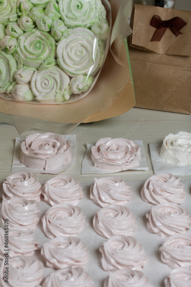 Homemade marshmallows in craft packaging. Zephyr in the form of a rose. Against the background of pine boards. Homemade marshmallows in craft packaging. Zephyr in the form of a rose. Against the background of pine boards.